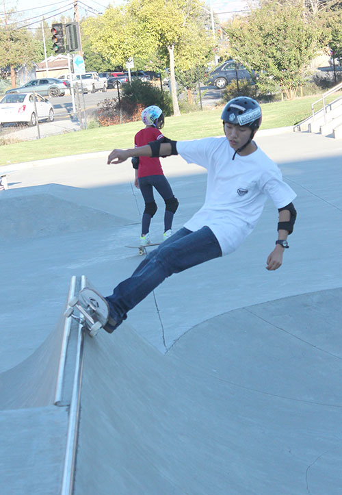 Roller blader female grinding on a ledge in a skatepark. Cool